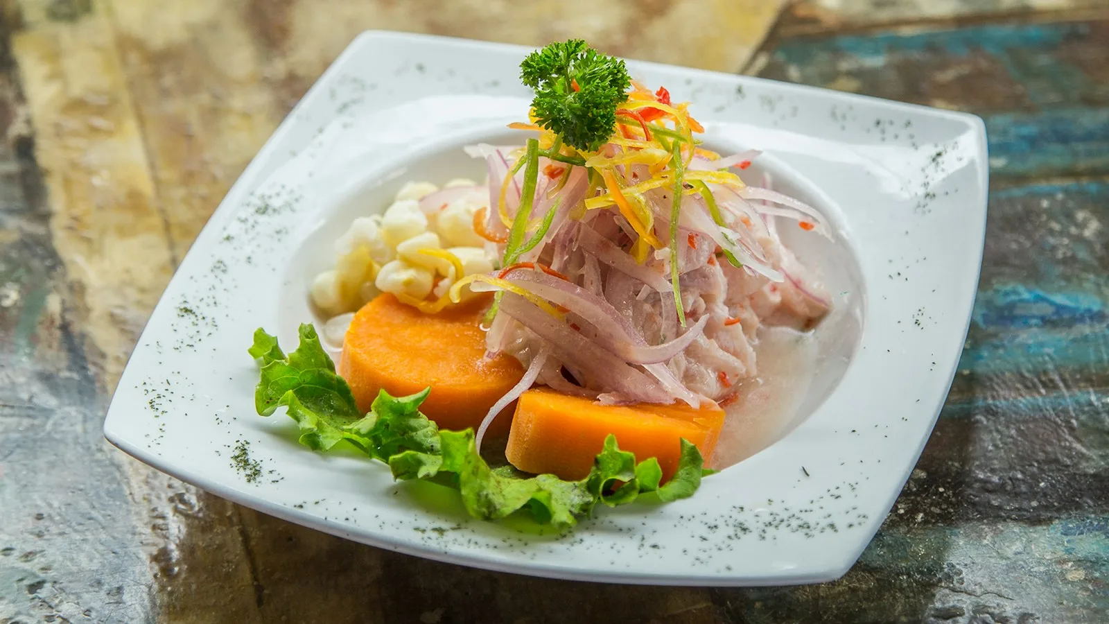 Assiette de ceviche péruvien avec patate douce et maïs choclo dans une cevichería de Lima